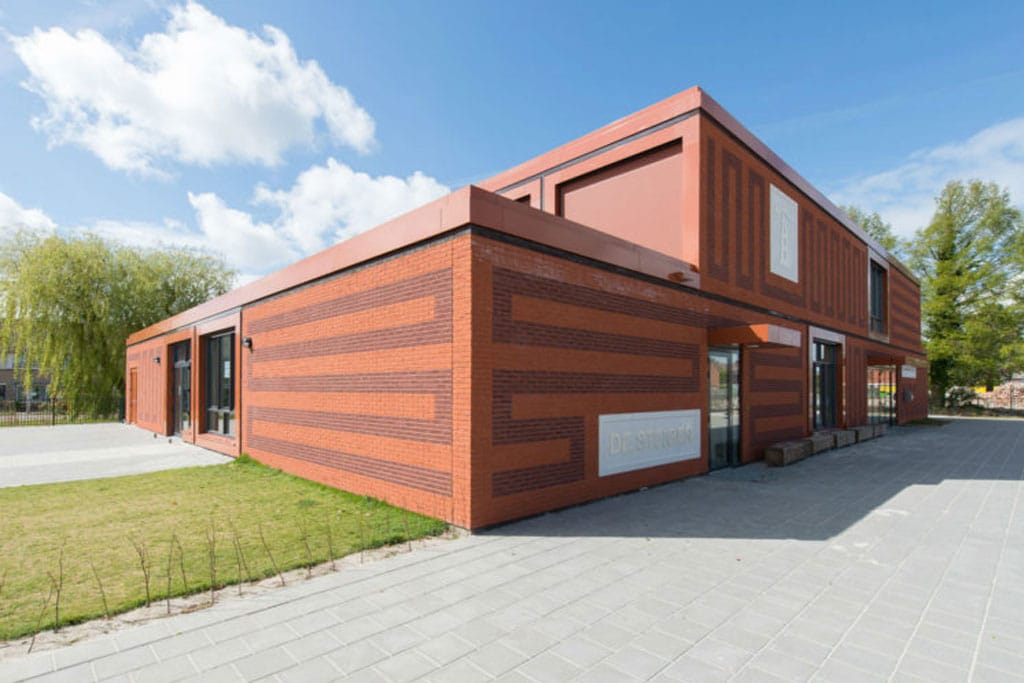 Rood gebouw met tekening in de gevel bij Lemstervaart