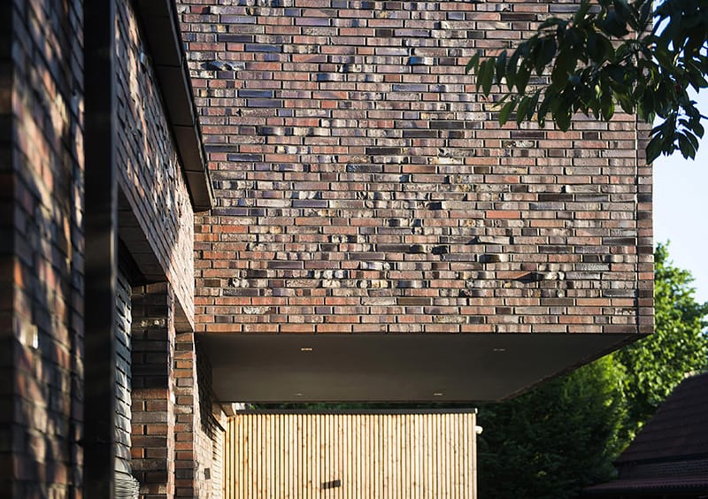 Muur met rough brick op een muur en een houten deur eronder