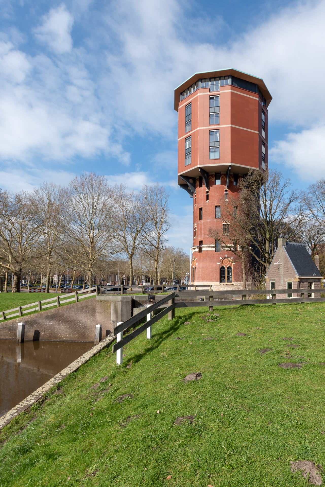 Zicht op Zwolse Watertoren met dijk en huisje op voorgrond