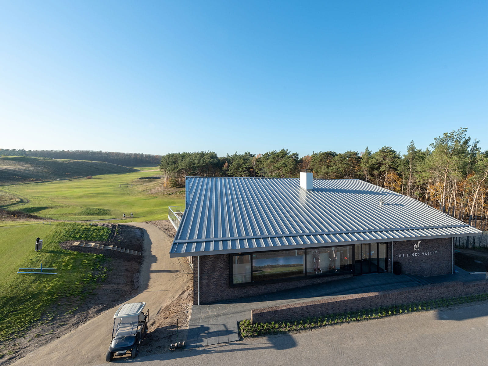 Uitzicht op een golfbaan met een gebouw op de voorgrond