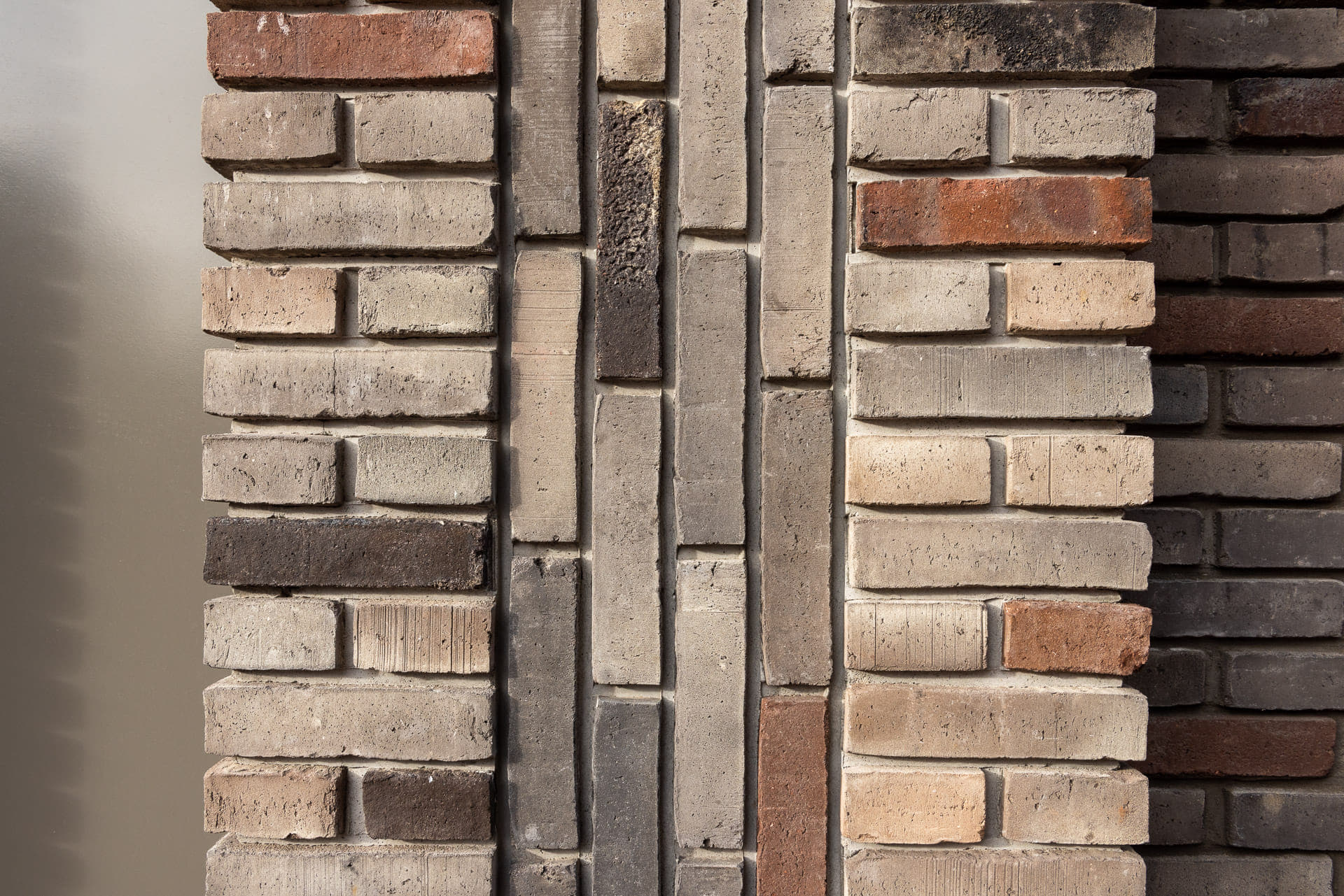detail van een muur met verticaal en horziontaal metselwerk van gekleurde lichte stenen