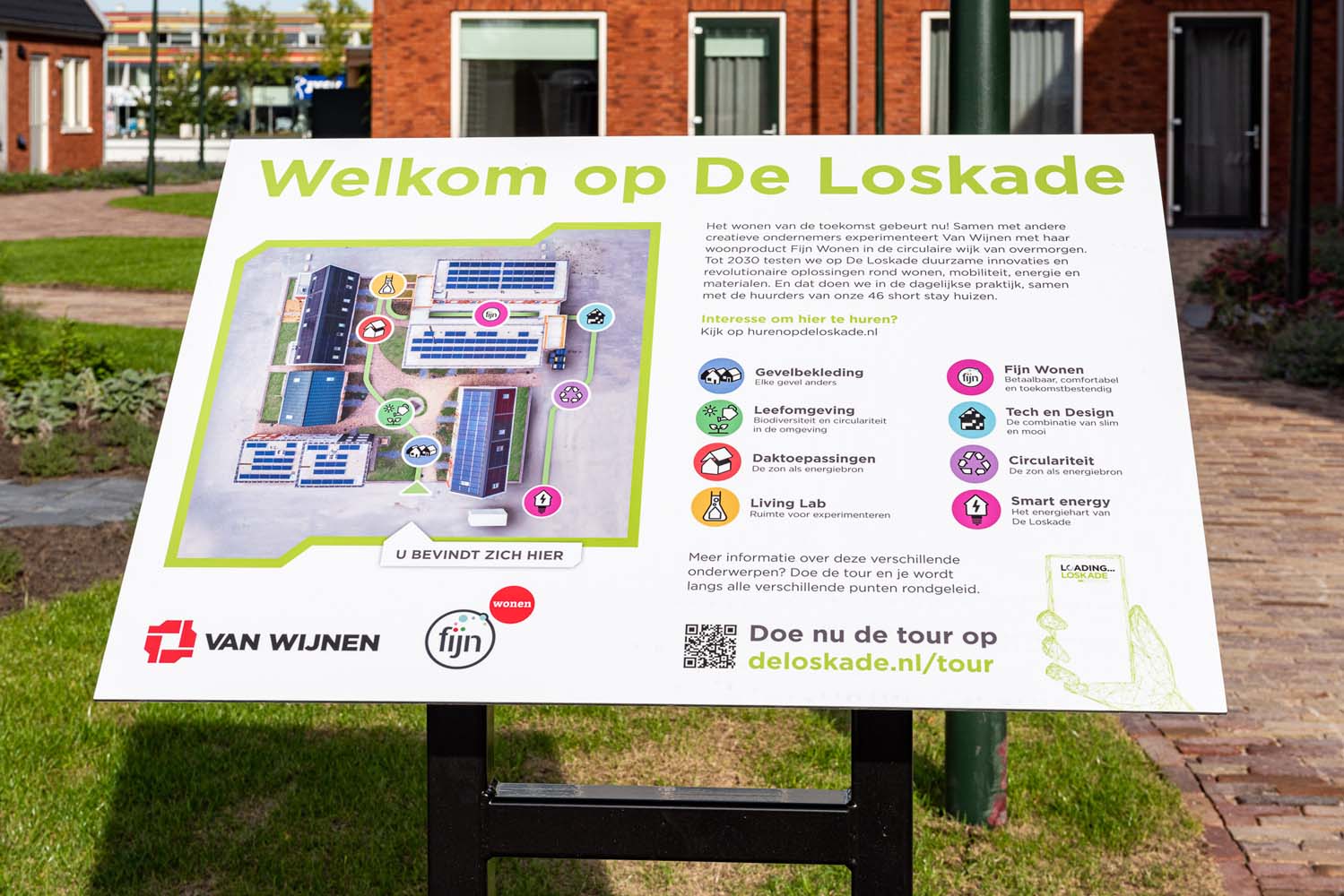 Bord met uitleg over circulair bouwen en leven op de Loskade in het gras van het pleintje