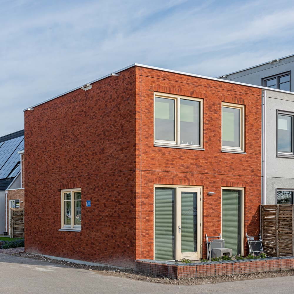 Een hoekhuis met een rode gevel op de Loskade