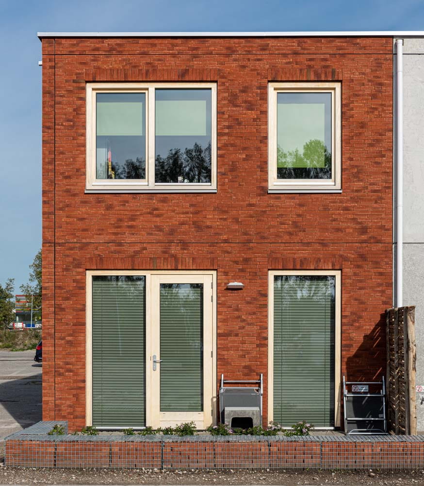 Een hoekhuis met een rode gevel op de Loskade
