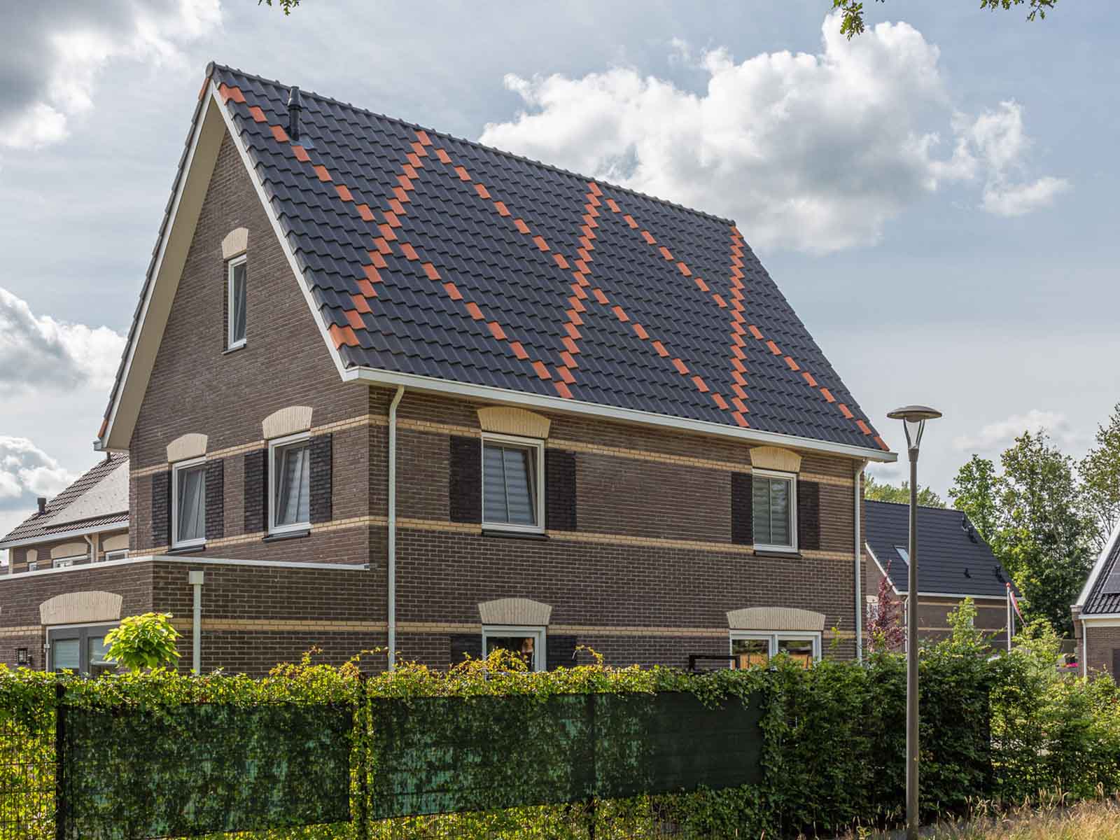 Huis met een dak waarbij de dakpannen een kruis hebben