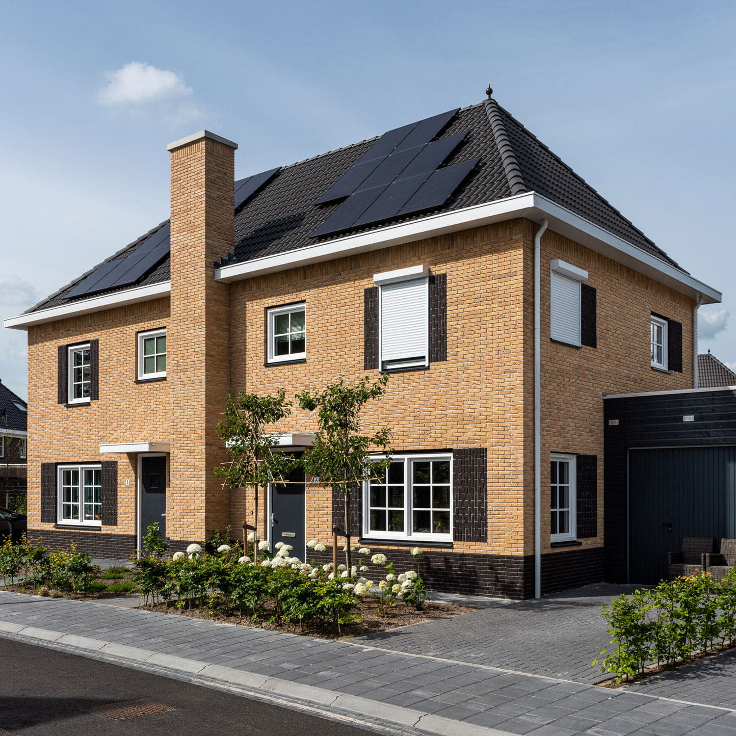 Twee-onder-een-kap woning met gelige baksteen en zwarte dakpannen