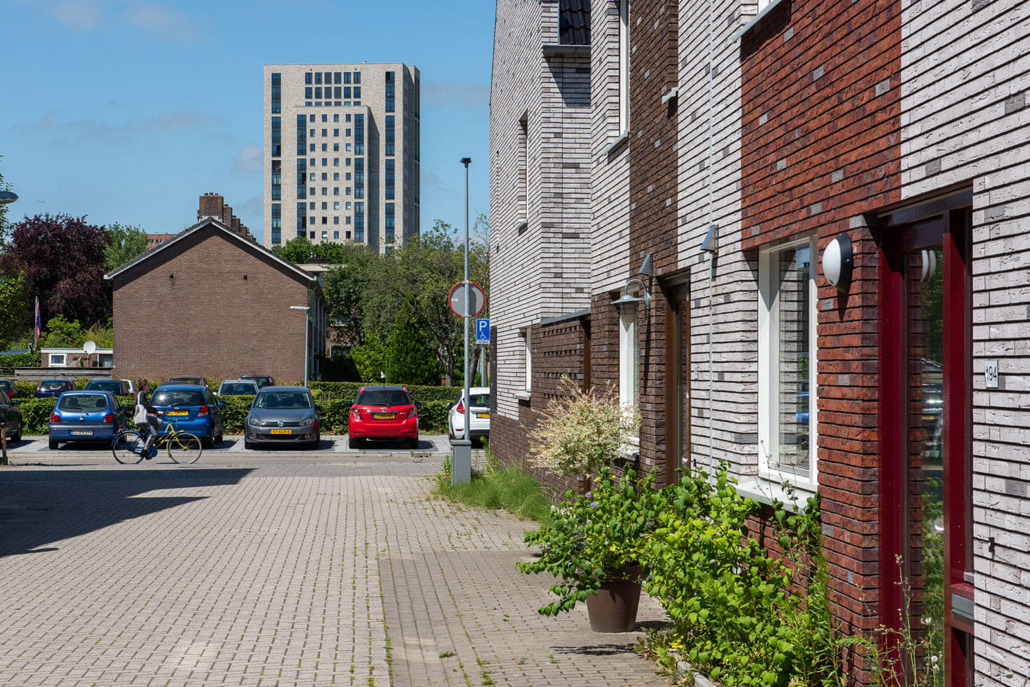Doorkijk in een straat naar een hoge lichte toren in de verte
